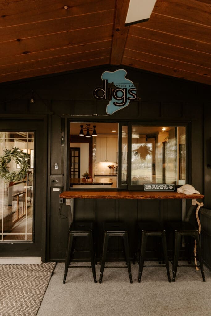 Alt Text: Indoor-outdoor bar seating at Camp Digs, perfect for a family-friendly cabin getaway Wisconsin experience